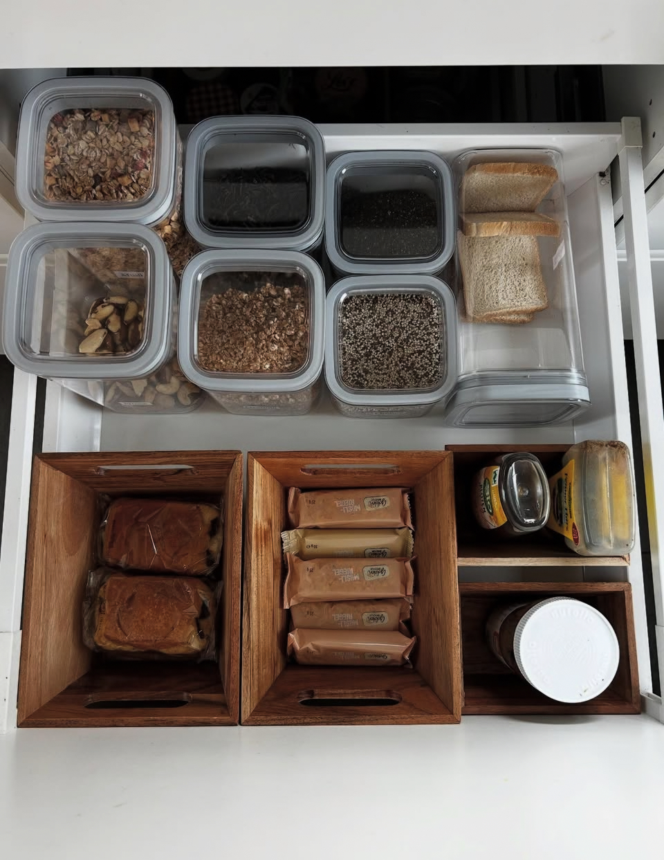 Organisierte Küchenschublade mit Behältern und Holzkisten